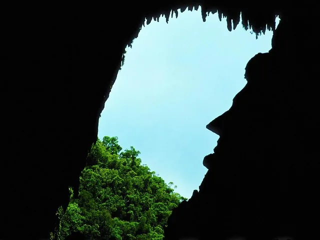 Entrada de la cueva en silueta contra el cielo, con forma de rostro de perfil.